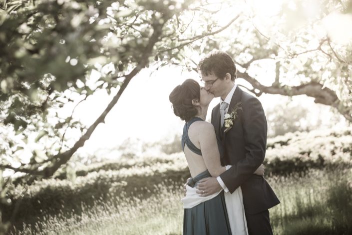 Bride & Groom kissing under apple tree