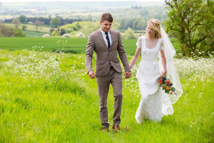 Bride & Groom walking through field