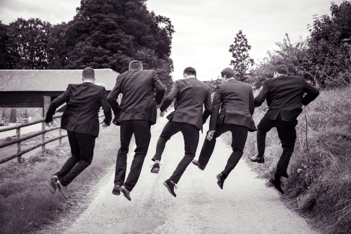 Black & White Grooms men leaping in air